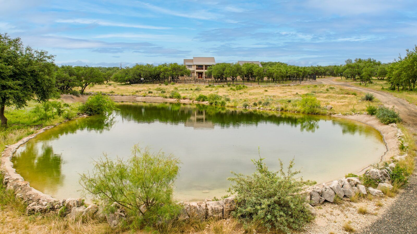 The concrete-lined stocked pond with the main lodge on the rise behind it