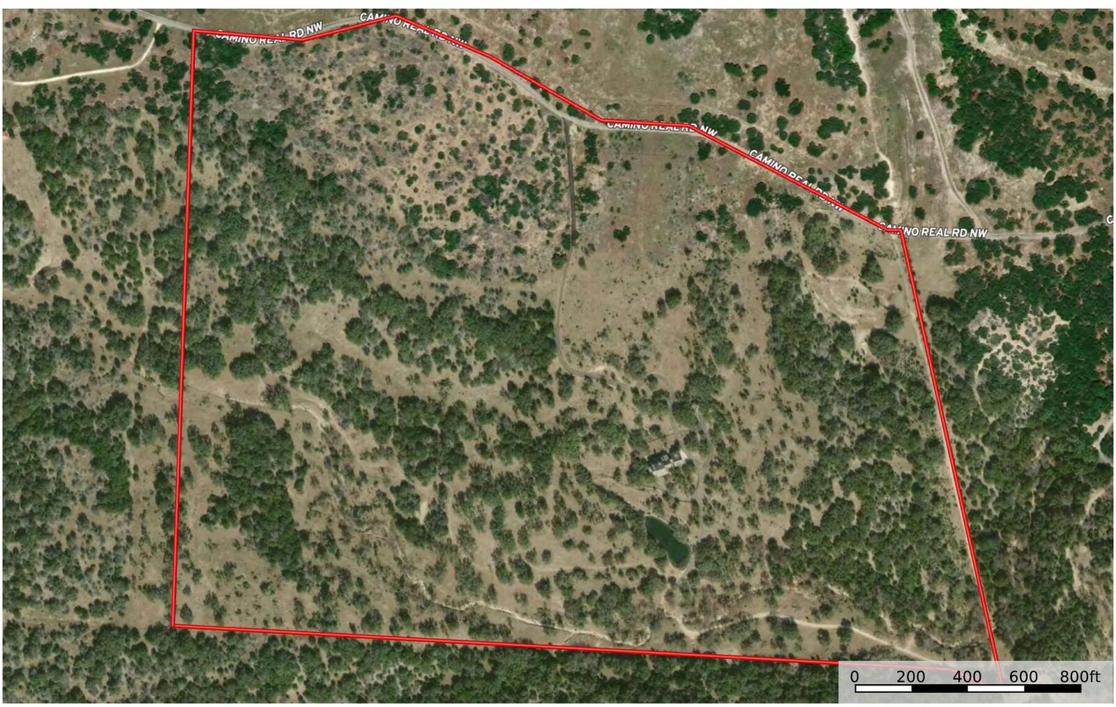 Overhead satellite view of the parcel with a drawn red boundary along Camino Real Road NW and a scale bar