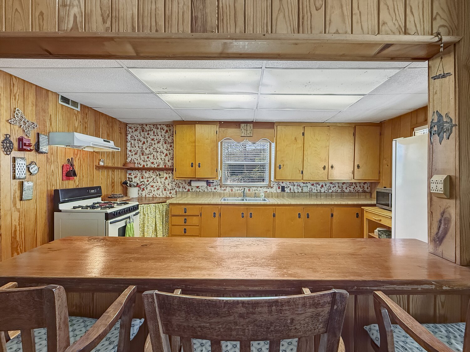 The eat-in kitchen at 150 Coker Hollow with pine cabinets, a gas range and a butcher-block bar across the front