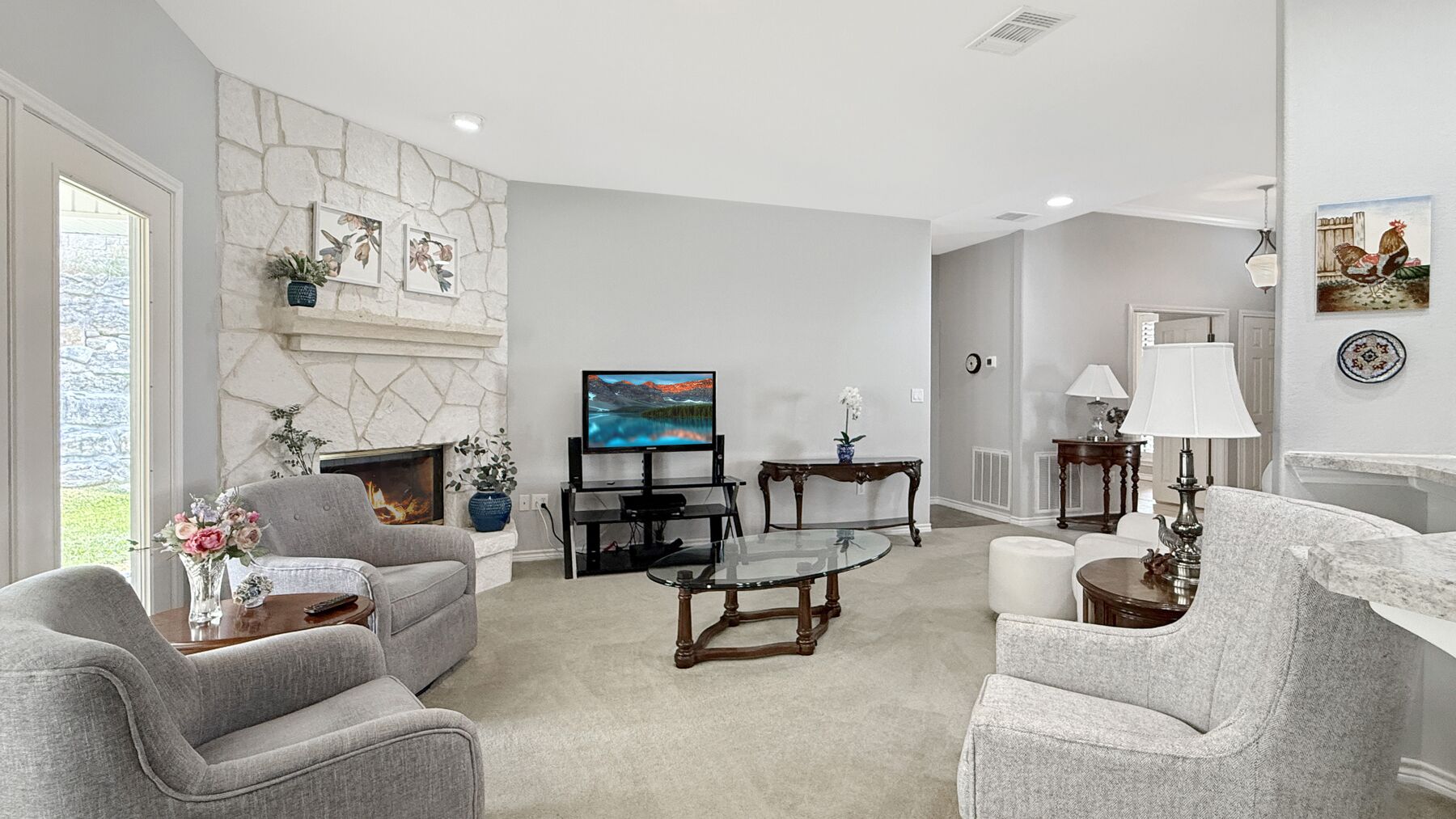 The living room at 2004 Athens Ave with a masonry stone fireplace, high ceilings and an open run through to the breakfast area and kitchen