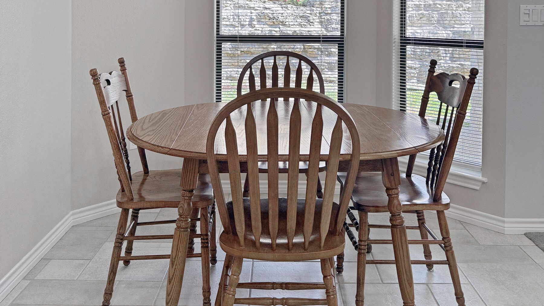 The breakfast area at 2004 Athens Ave — a round table under a light fixture, with tall windows across the back wall