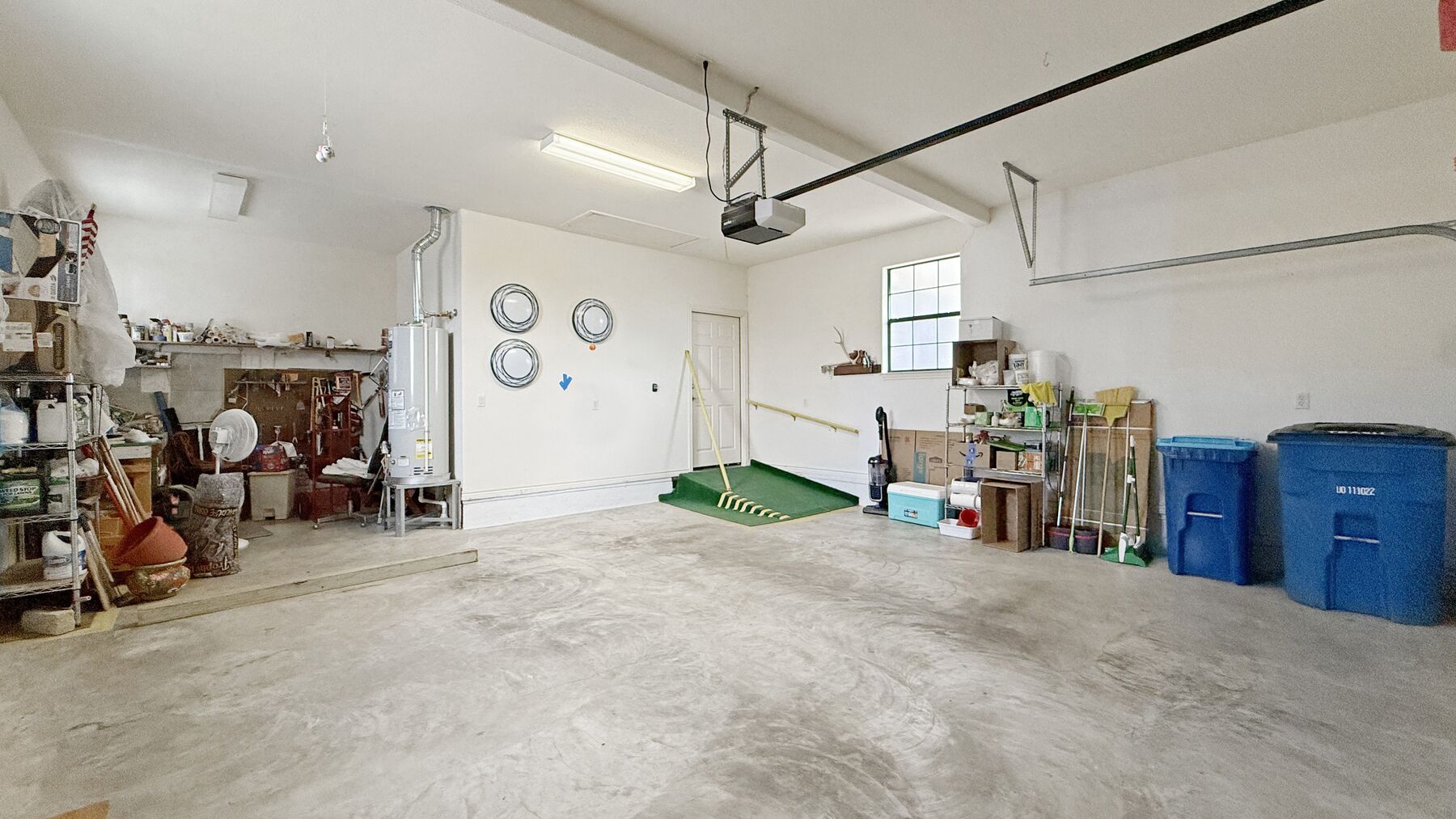 The attached two-car garage at 2004 Athens Ave, with a workshop area along the side wall and an overhead door opener